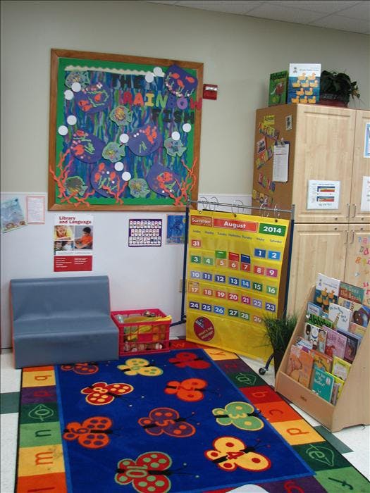 Children's classroom with a butterfly rug, calendar, and bulletin board