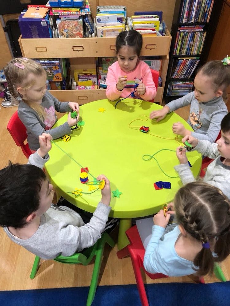 Children sitting around a table playing with toys