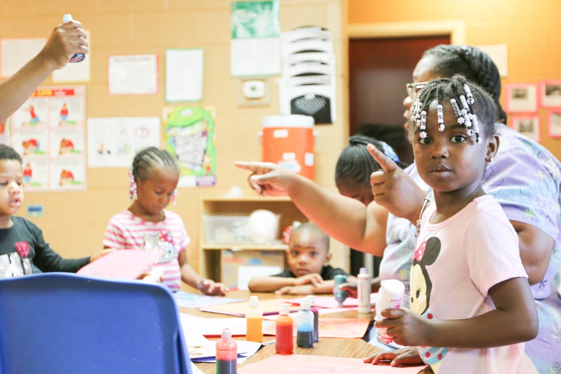 Children and adults at a table with craft supplies