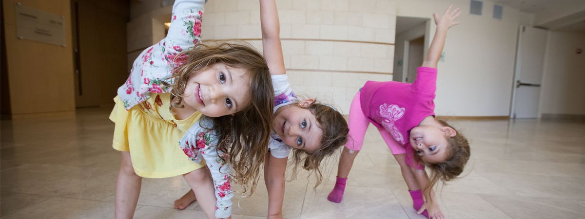Three children doing a side bend pose