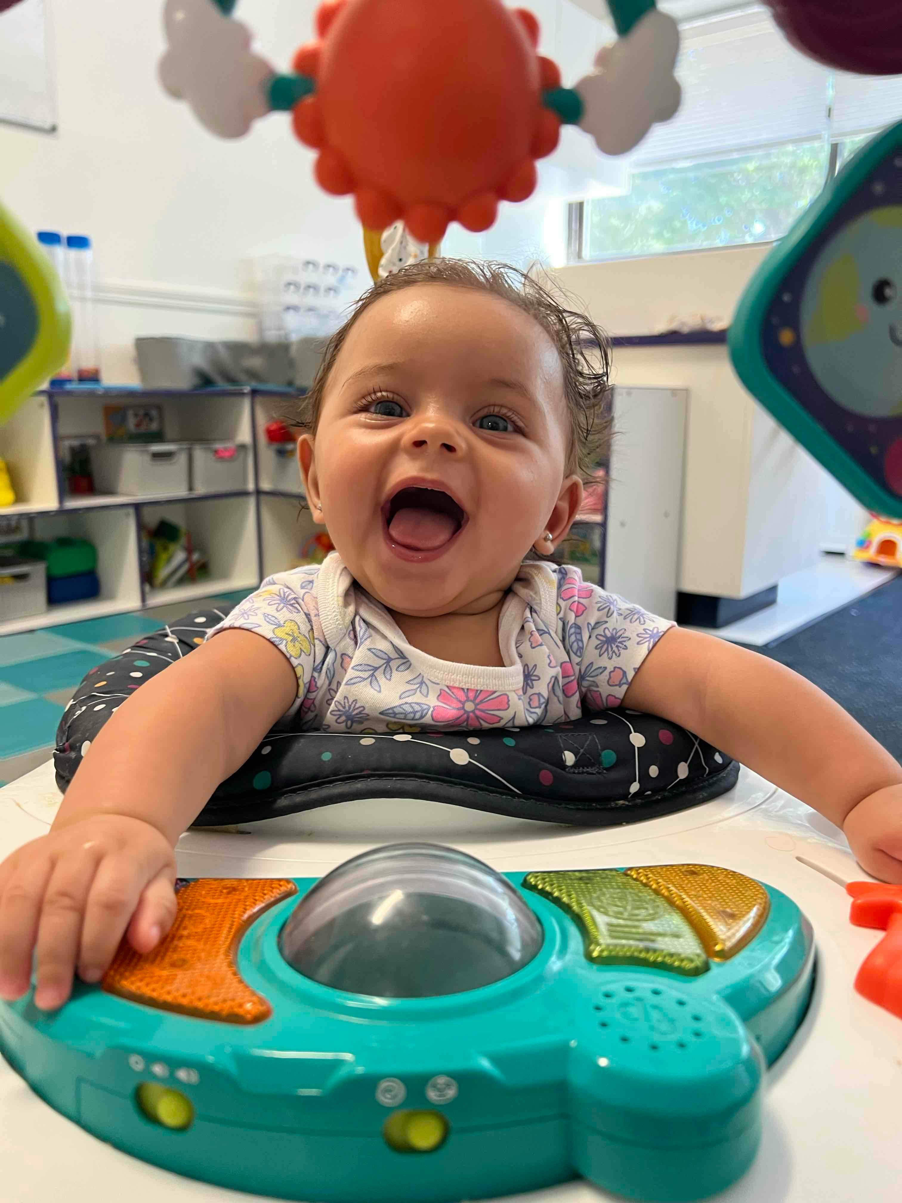 Child in a high chair playing with a toy
