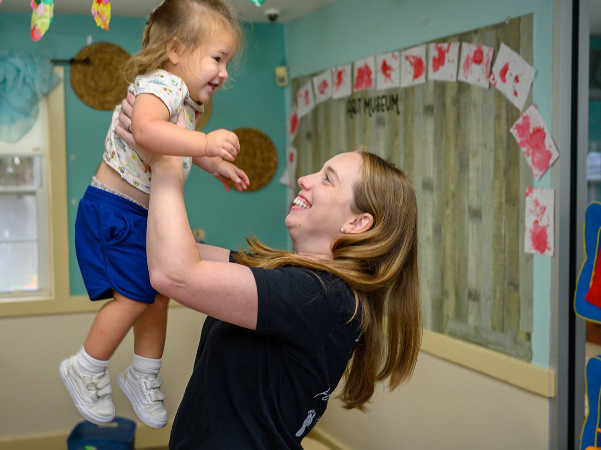 Person holding a child up in the air