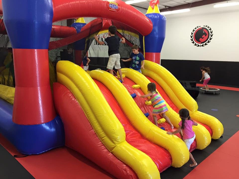 Children playing on a large inflatable slide and a trampoline