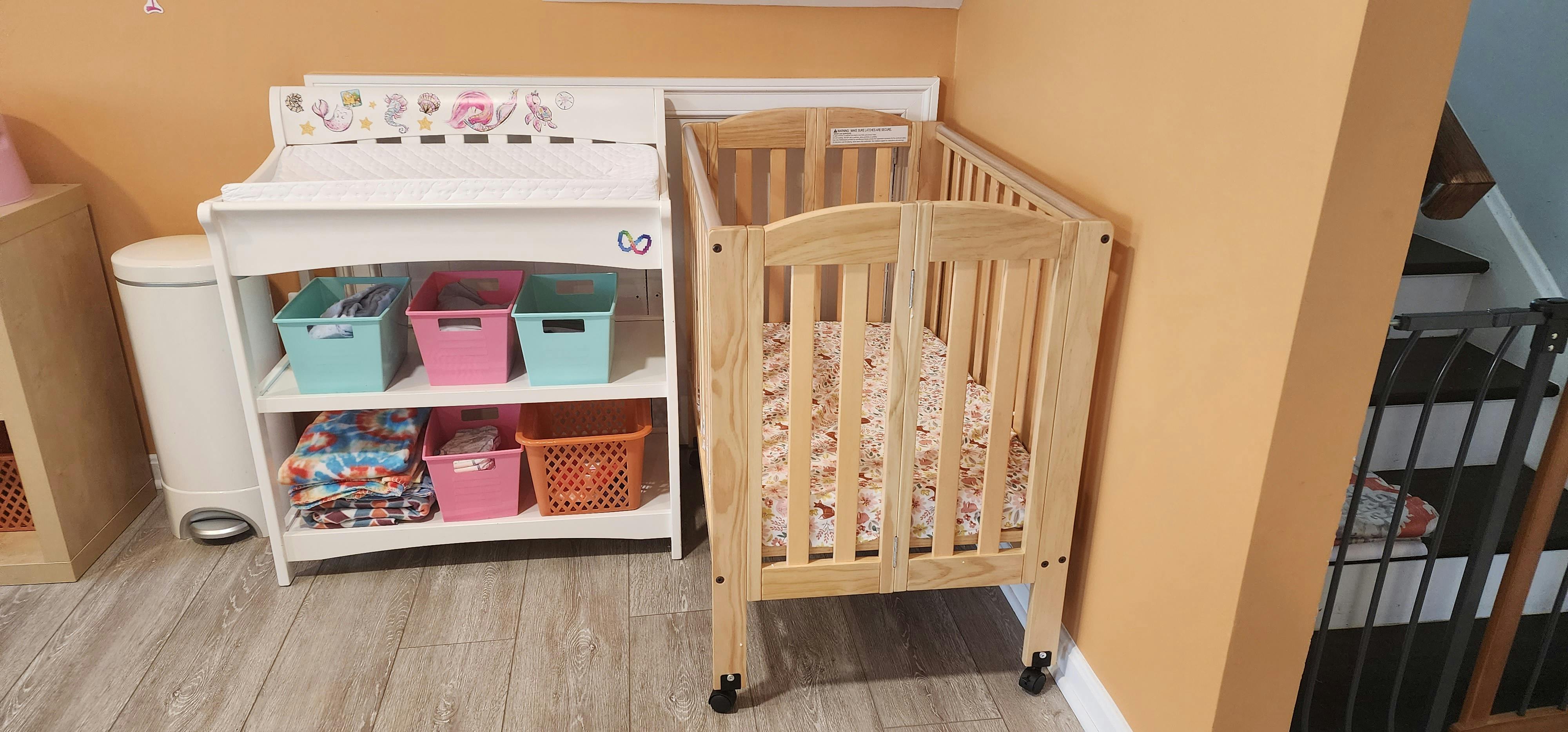 Changing table with storage bins and a crib