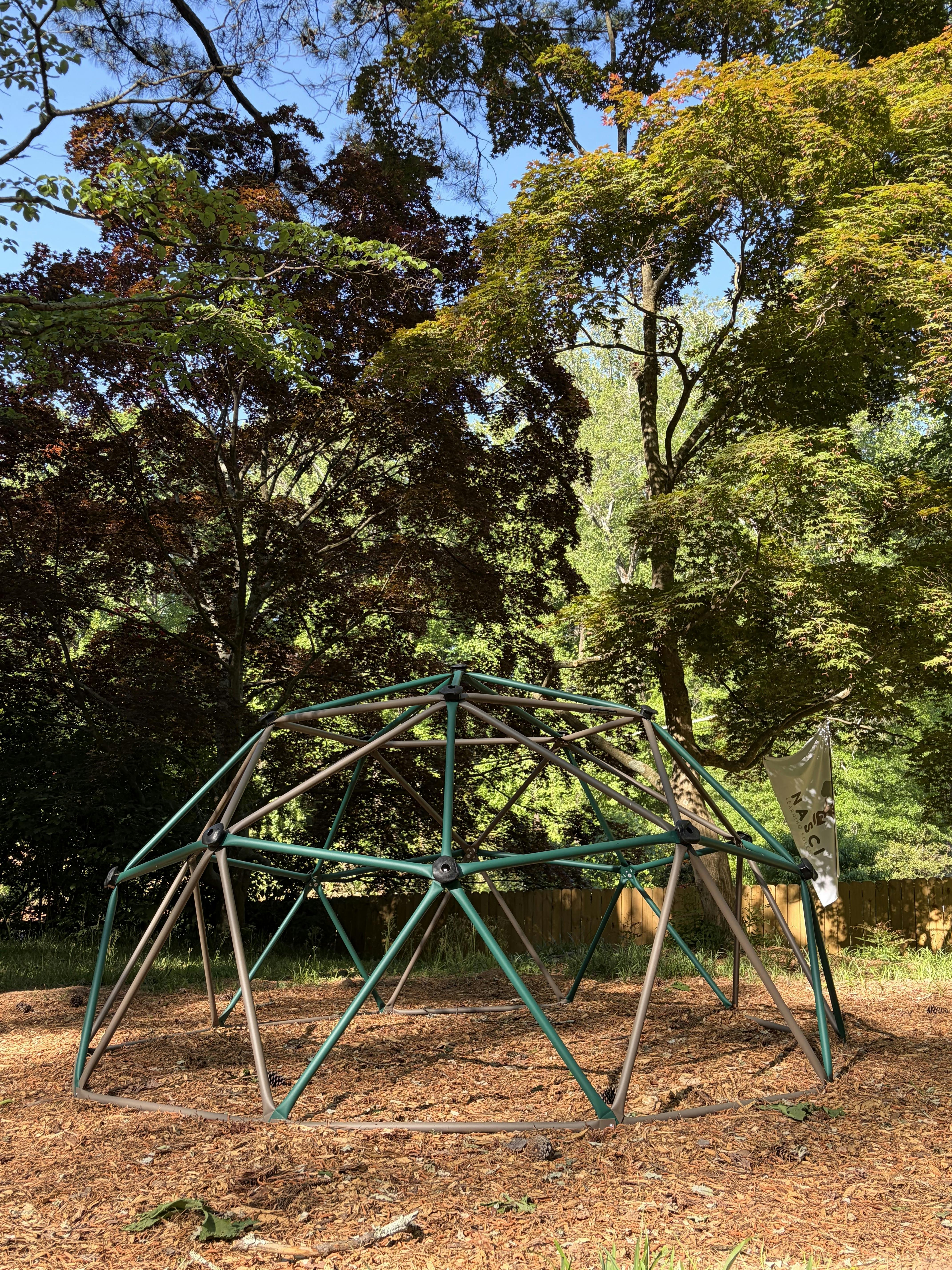 Geodesic dome climbing frame in a wooded area