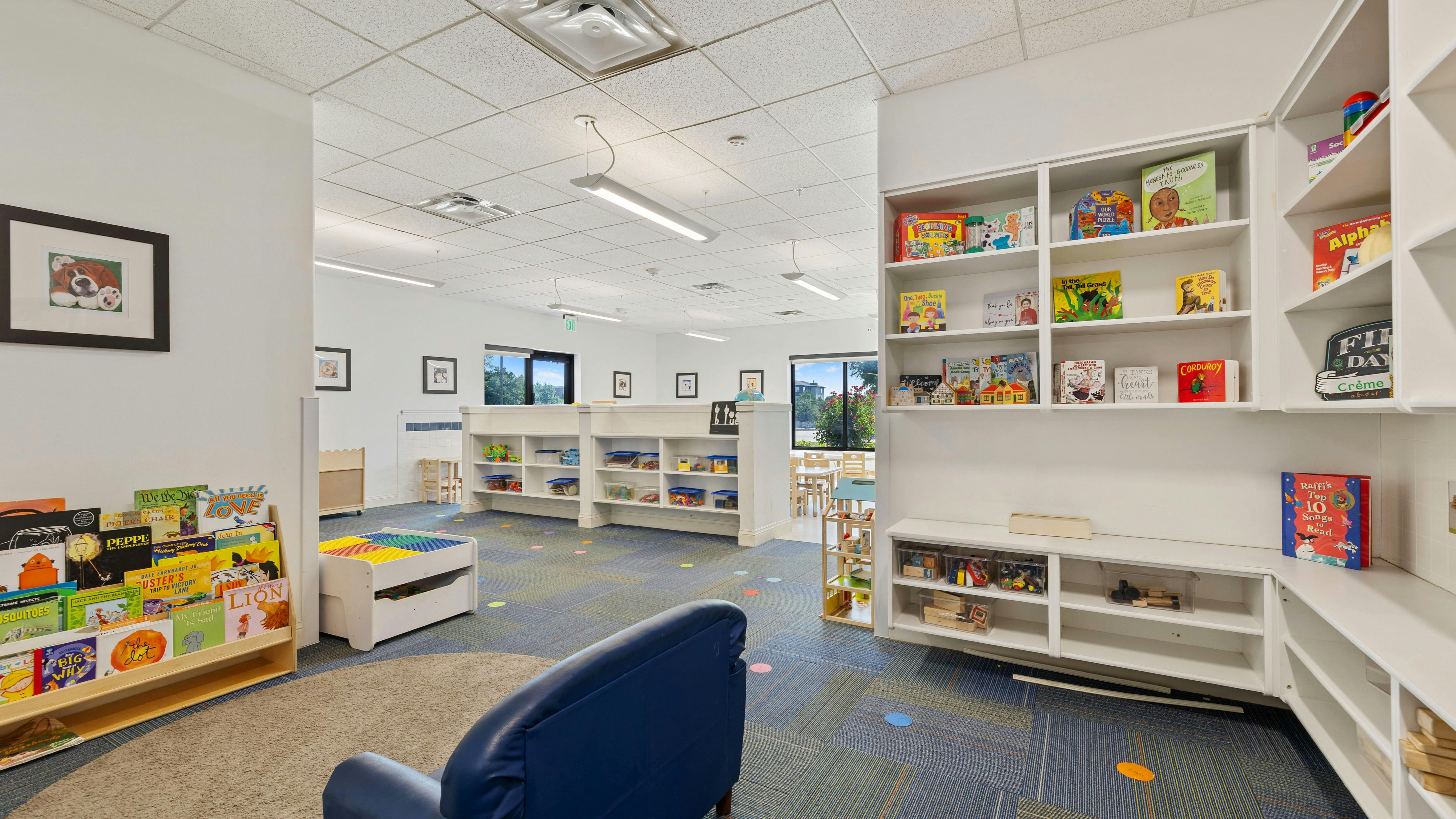 Classroom with bookshelves, child-sized furniture, and an exit sign