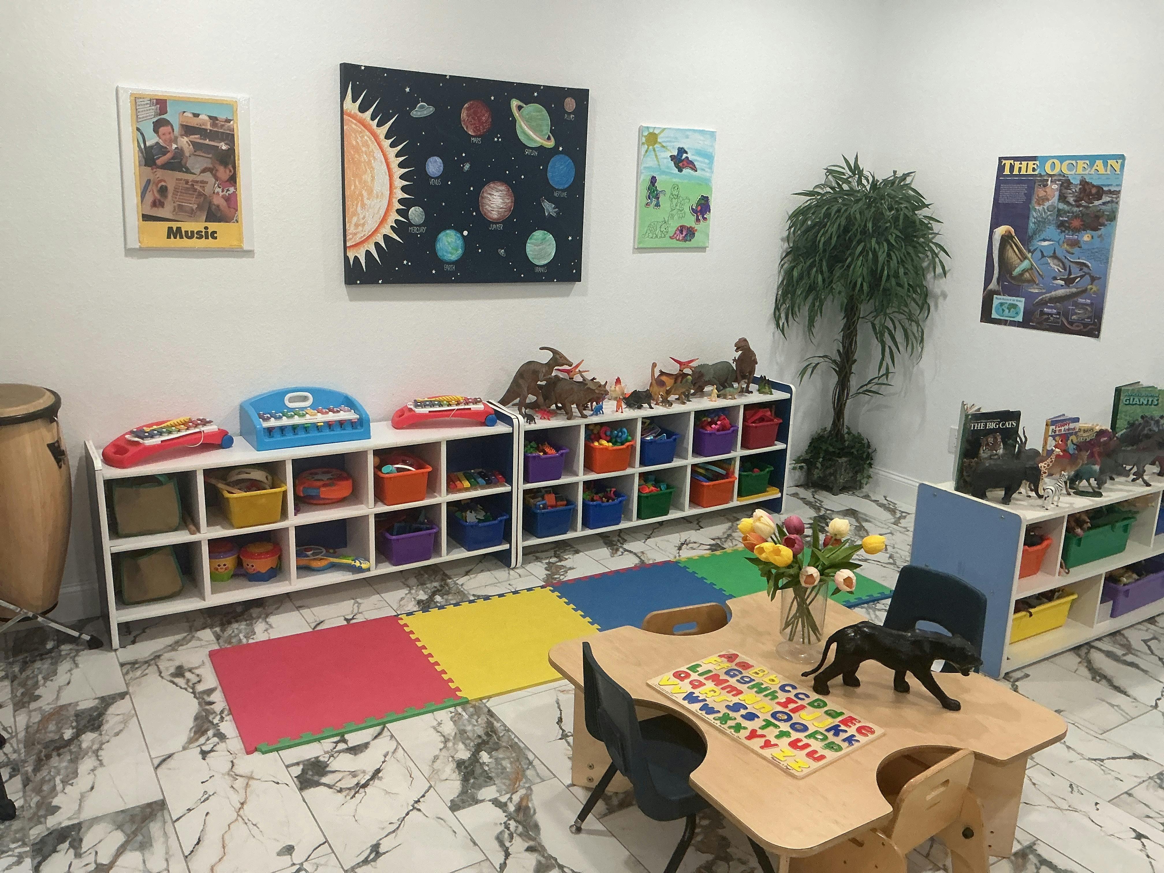 Classroom with toy storage shelves, a table with an alphabet puzzle, and wall art
