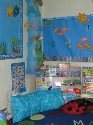 Classroom with blue ocean-themed decorations, alphabet chart, and books