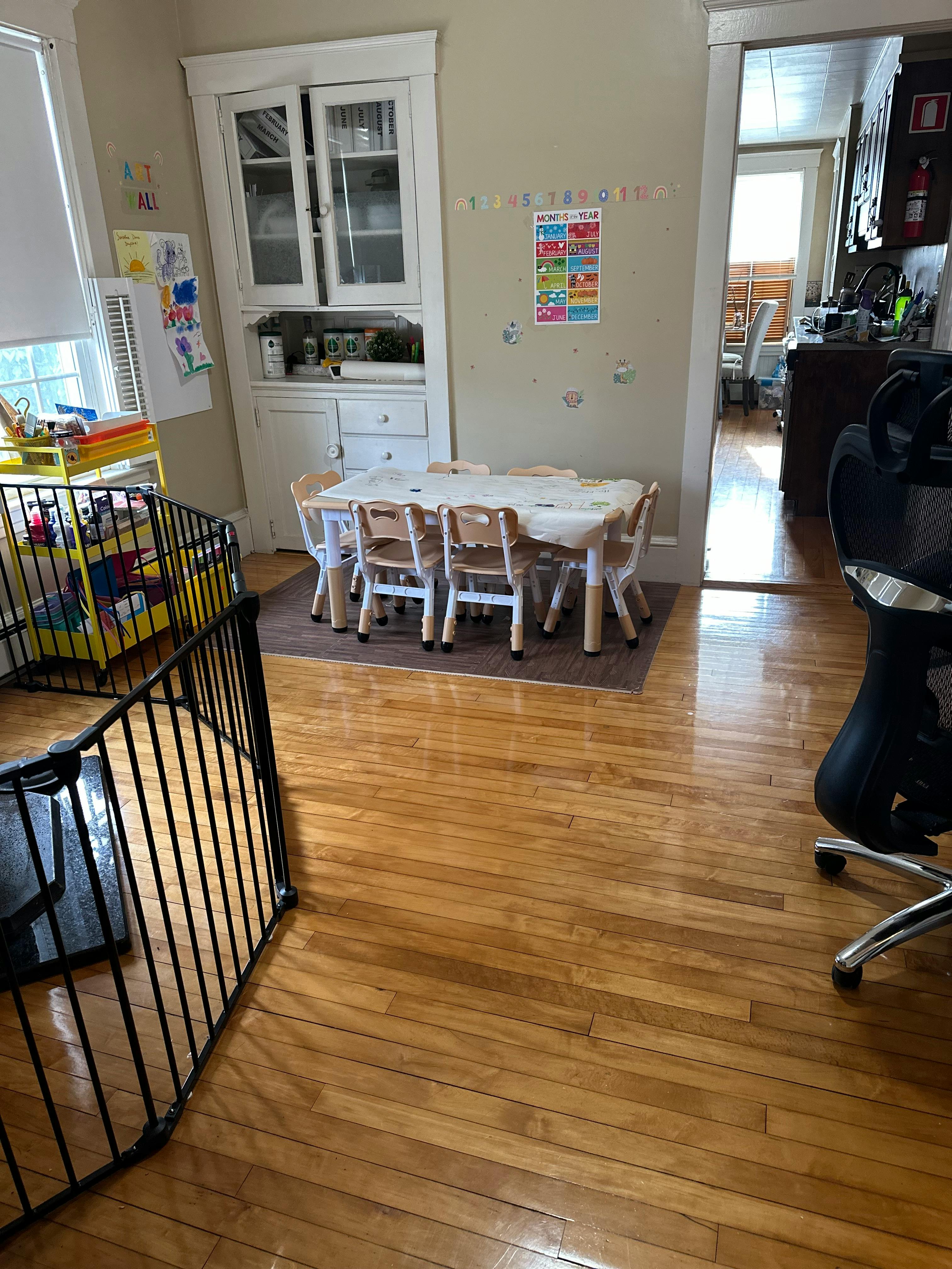Small table with chairs in a room with a playpen and built-in cabinet