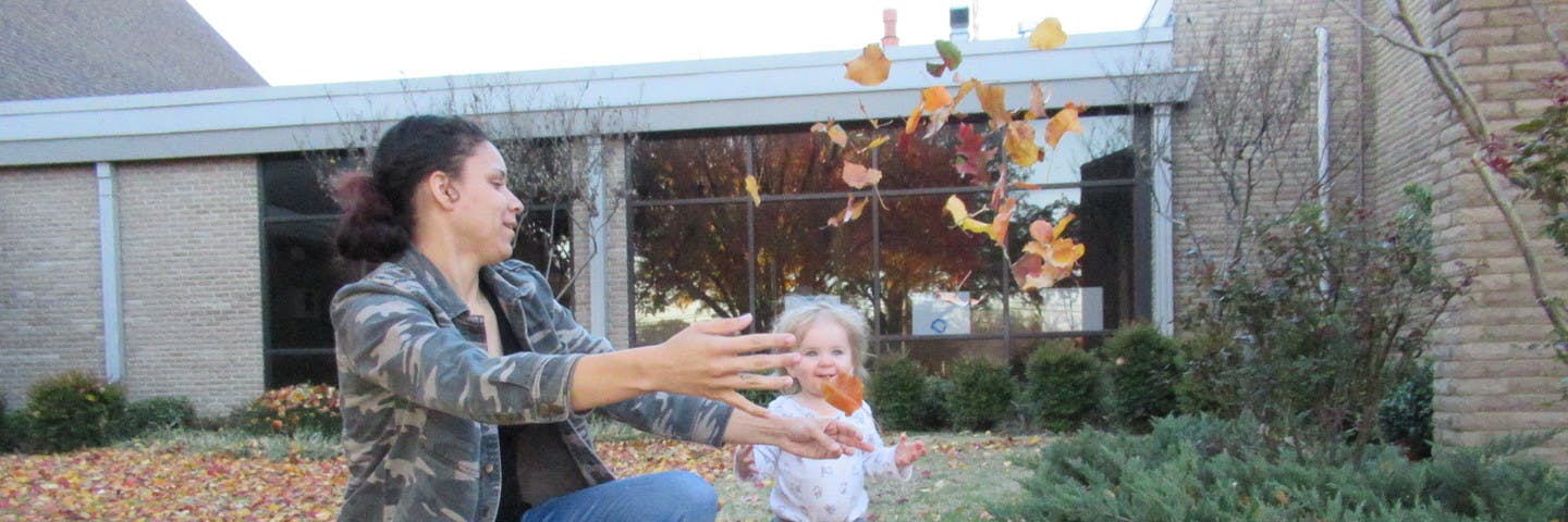 Person and child playing with leaves