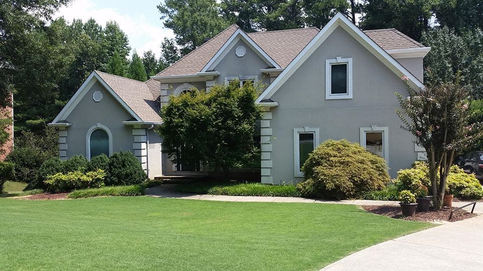 Large house with a green lawn and trees