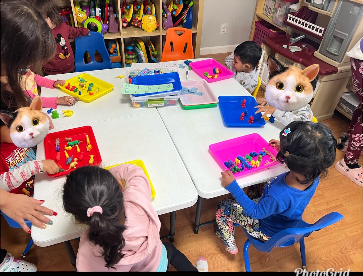 Children at tables playing with small objects
