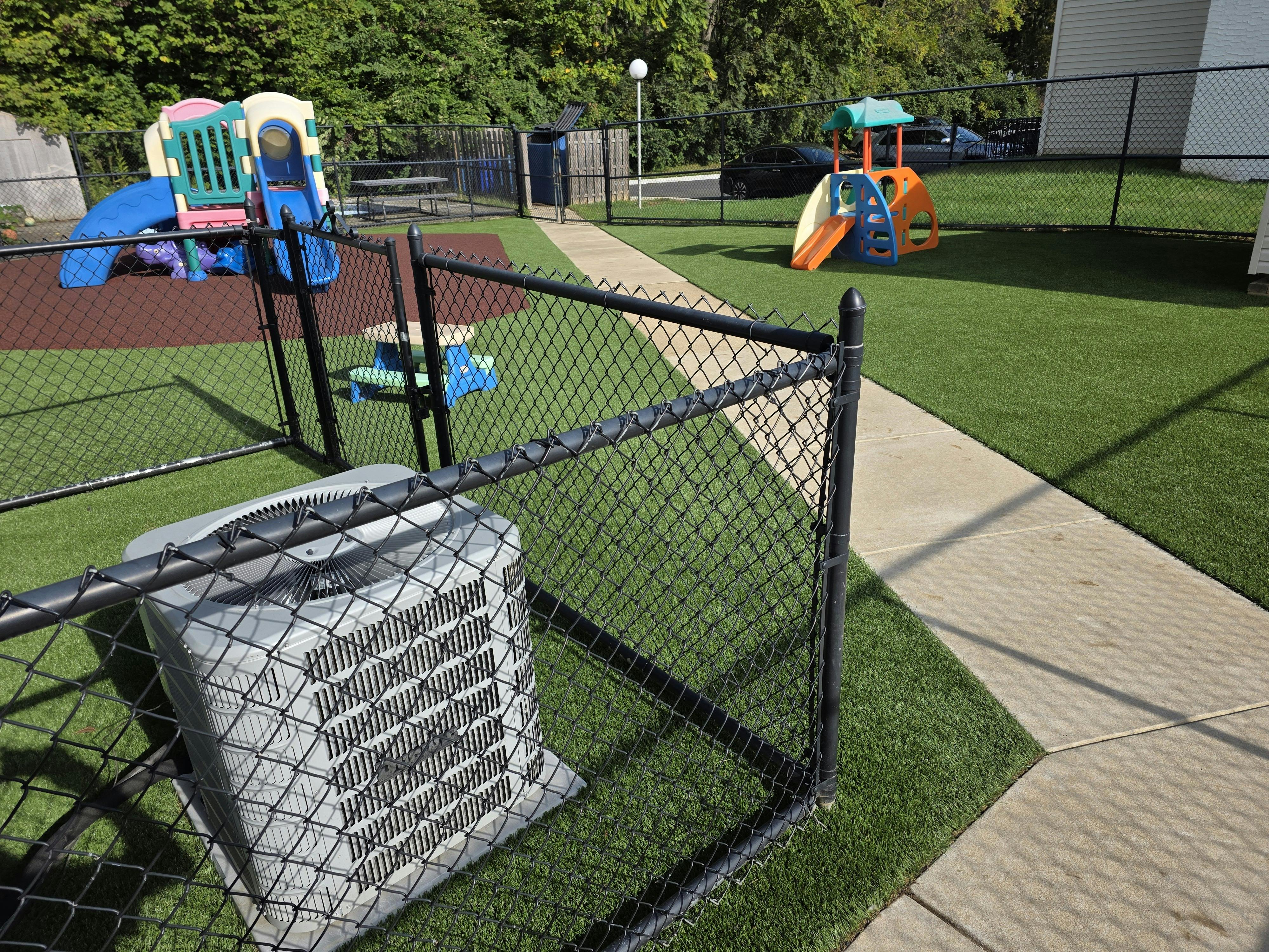 Playground with colorful slides and fences on artificial turf