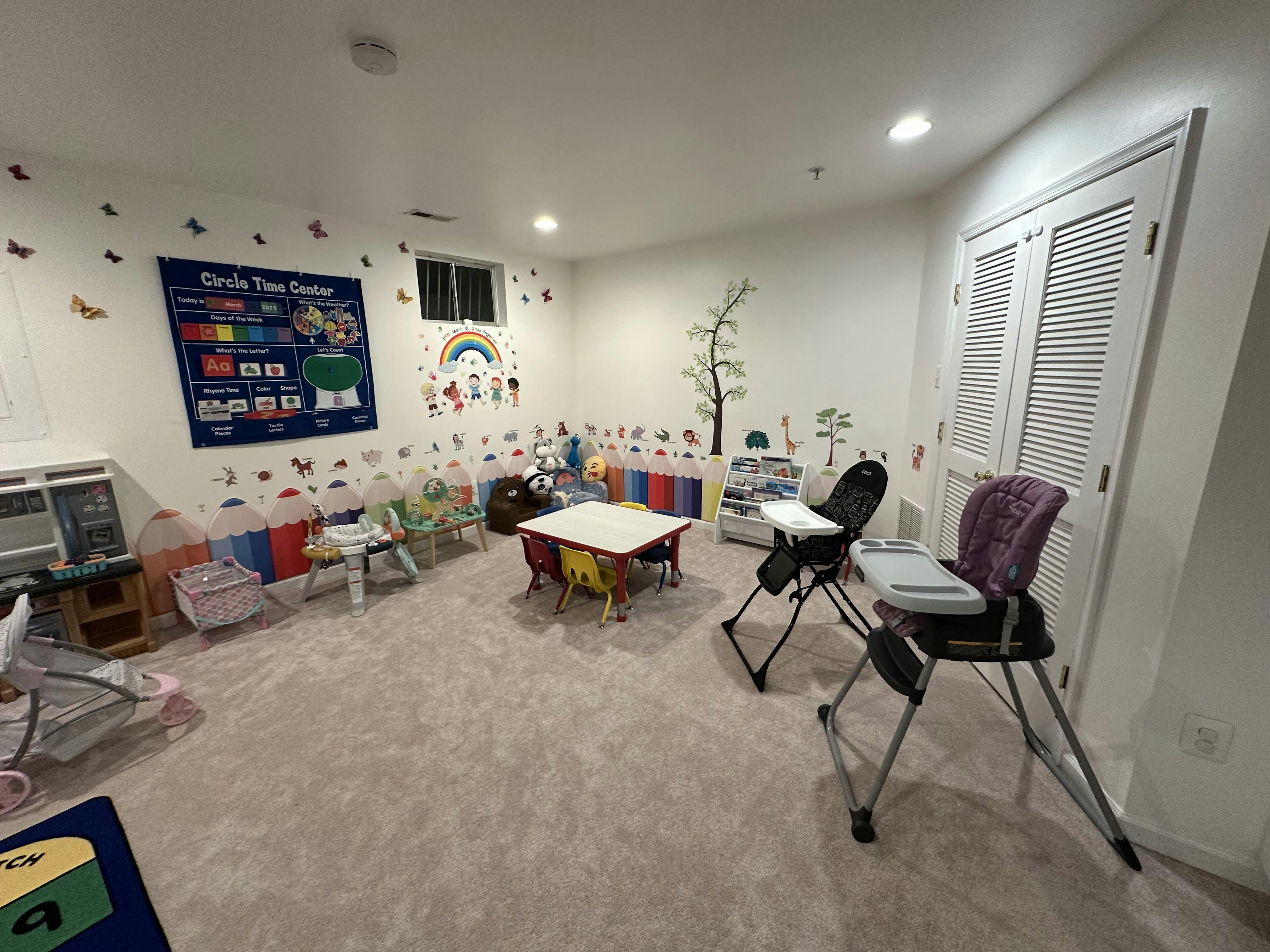 Playroom with small tables, chairs, and wall decorations