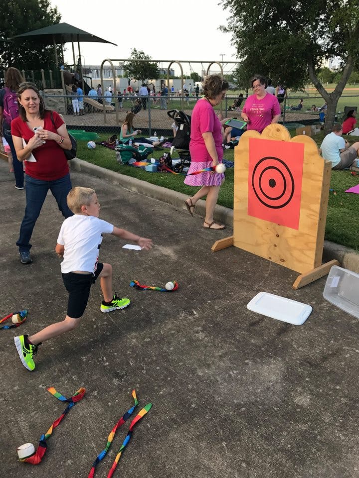 Child throwing a beanbag at a target board