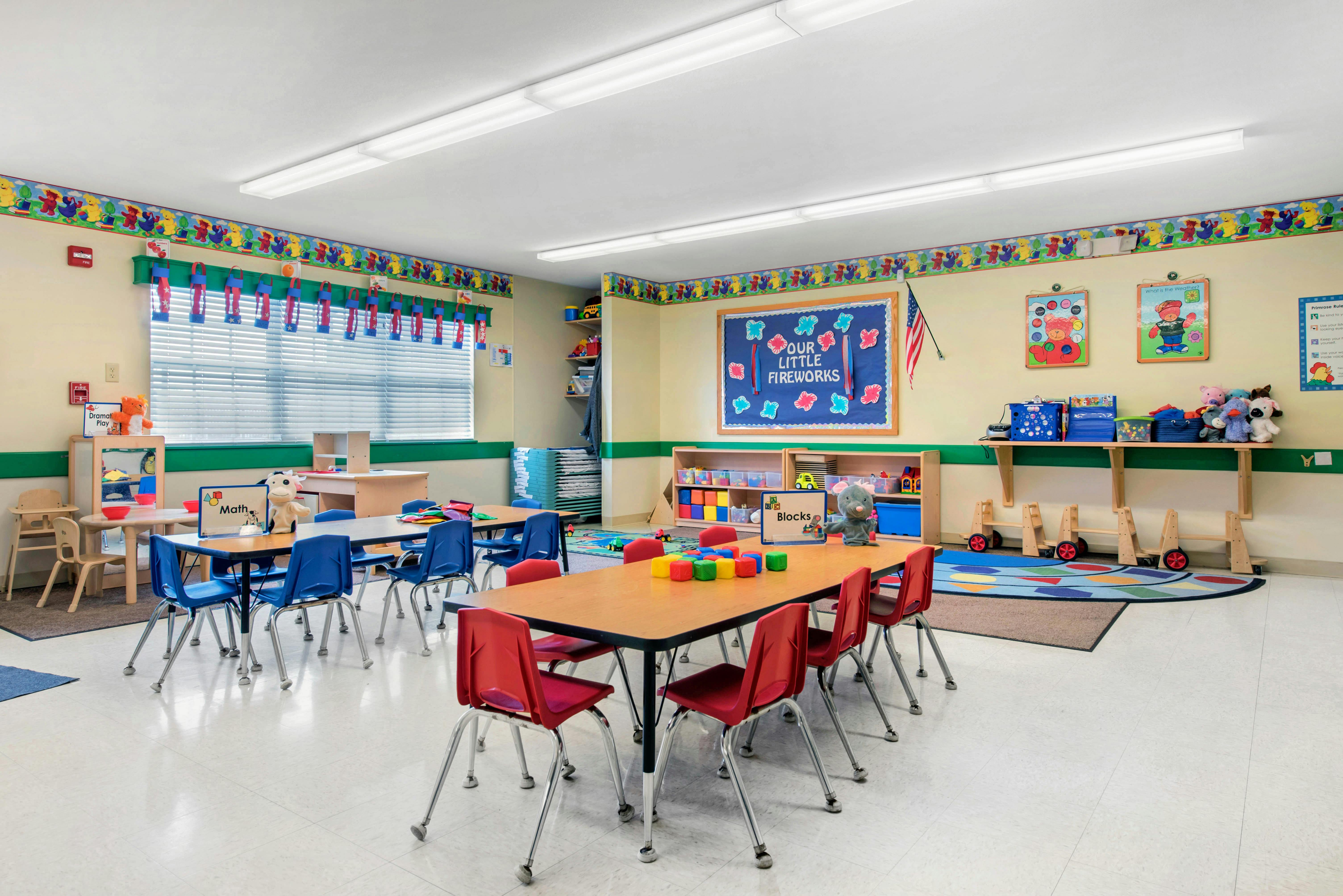 Colorful classroom with several small tables and chairs for children