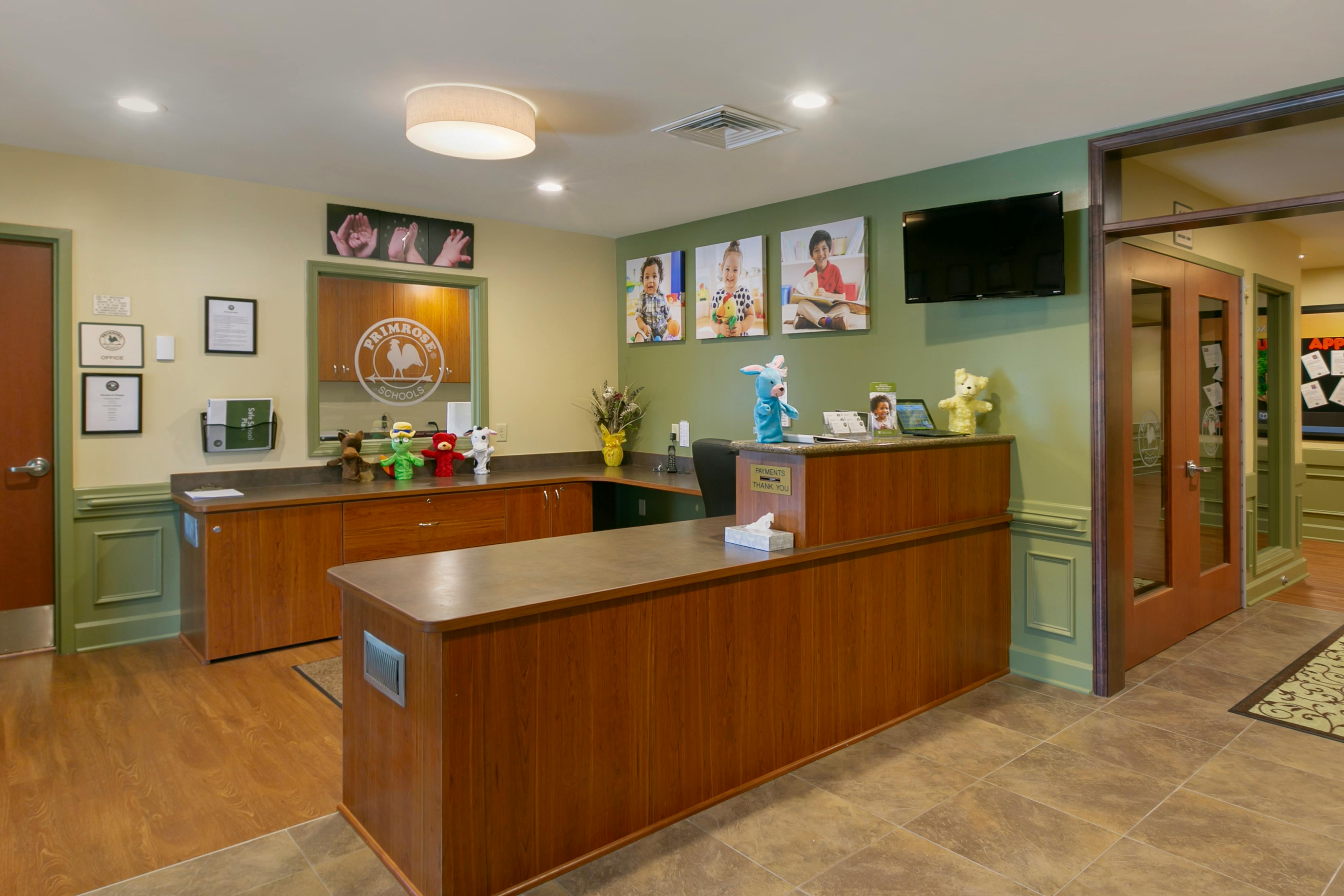 Reception area in a school with a front desk, pictures of children, and toys