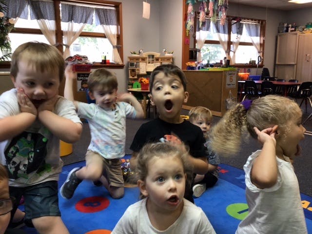 Group of children with surprised expressions in a classroom
