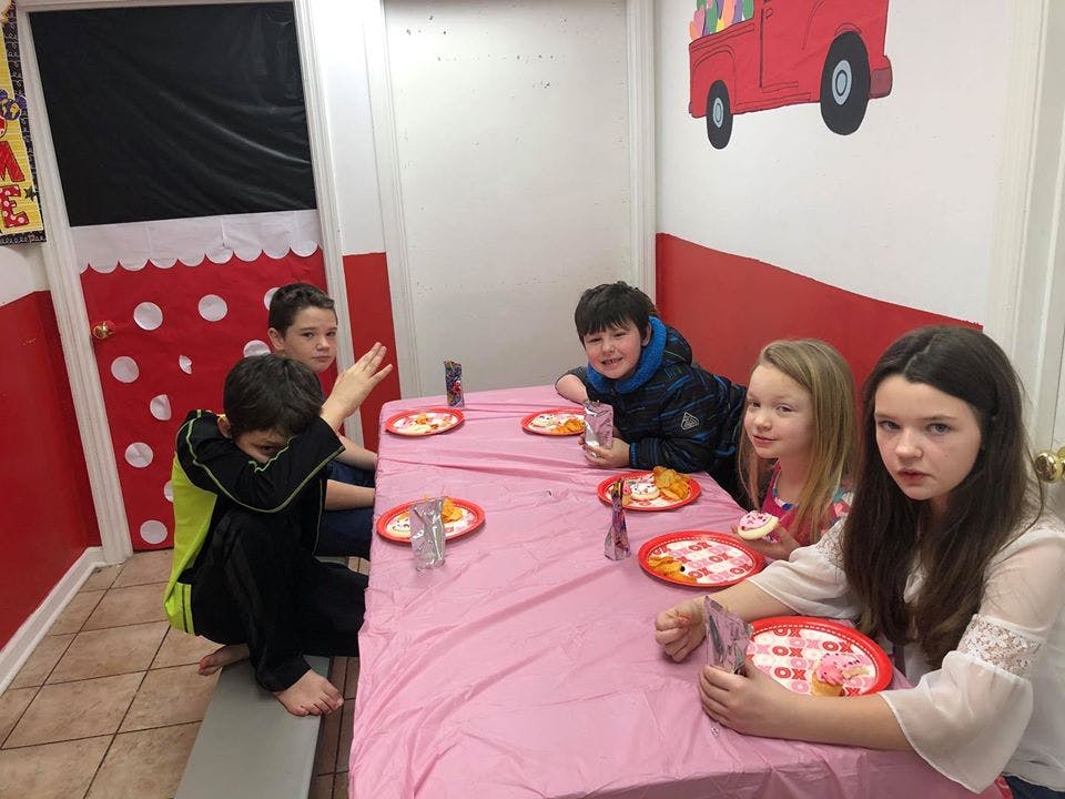 Children sitting at a table with plates of food