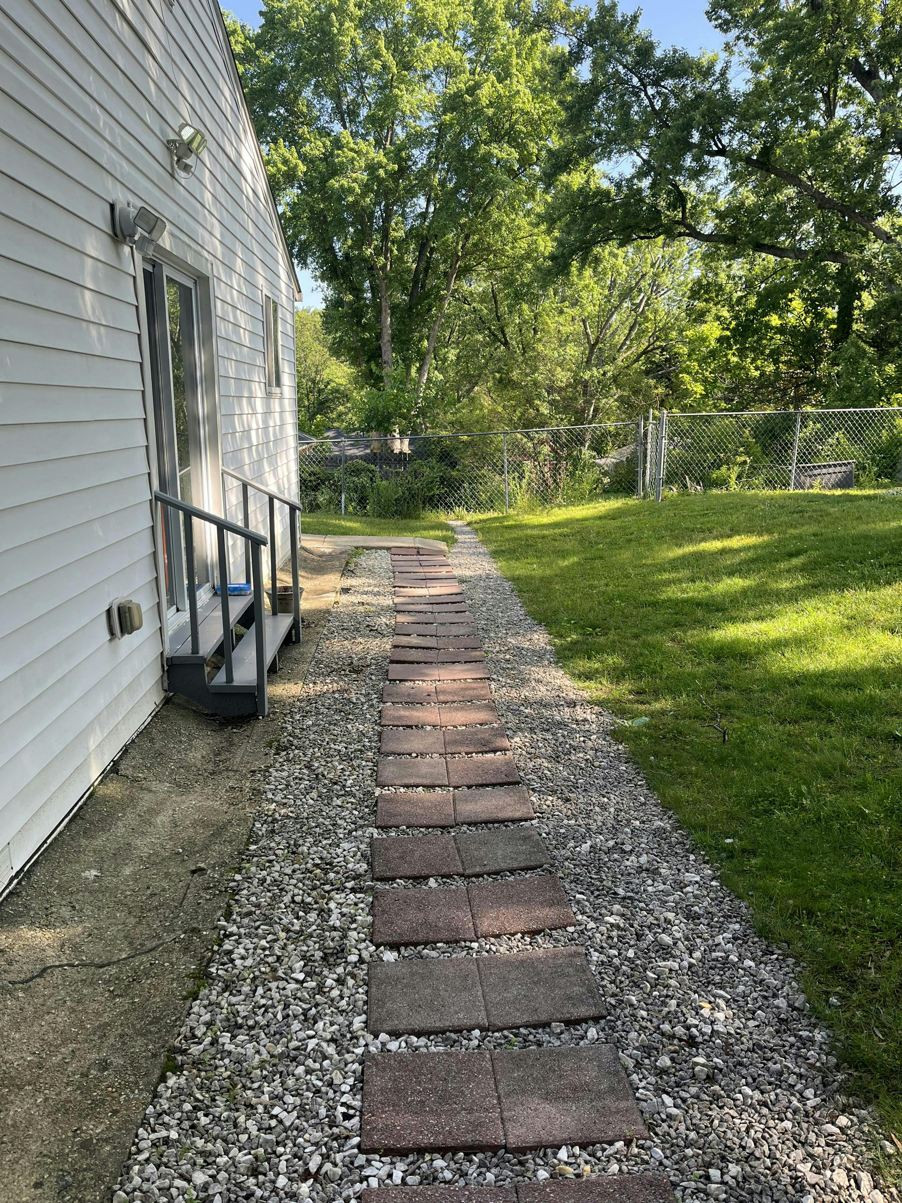 Stepping stone path next to a house and green lawn
