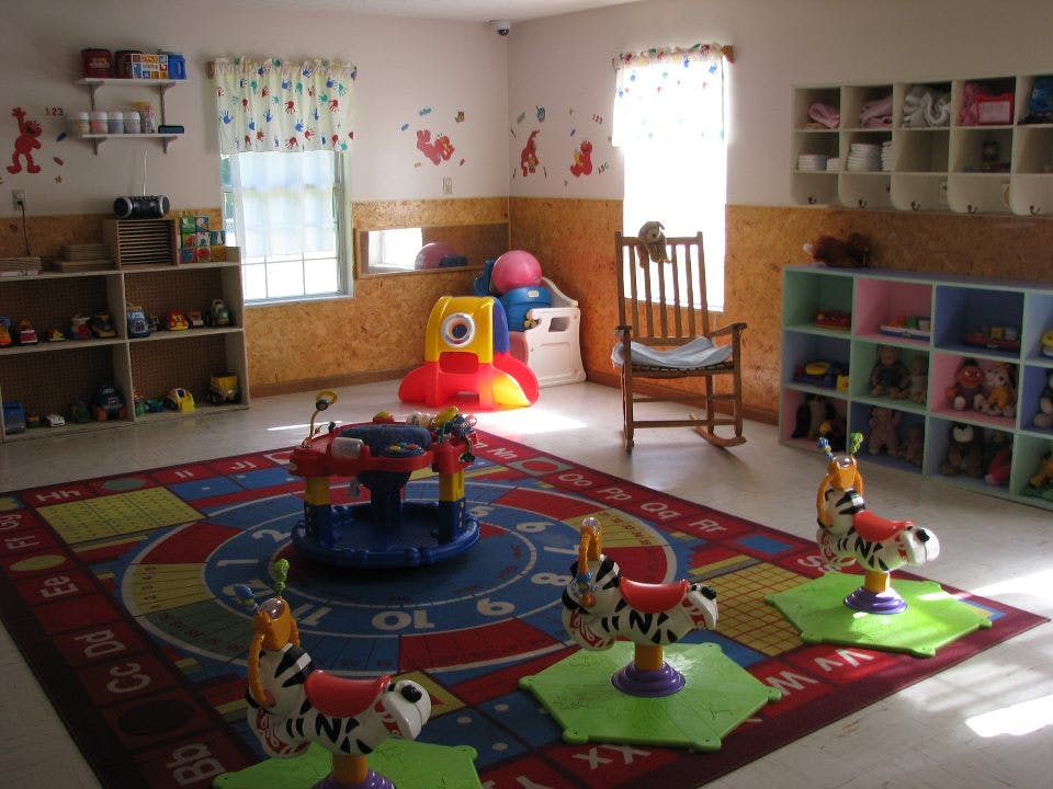 Playroom with colorful rug, toys, and shelves