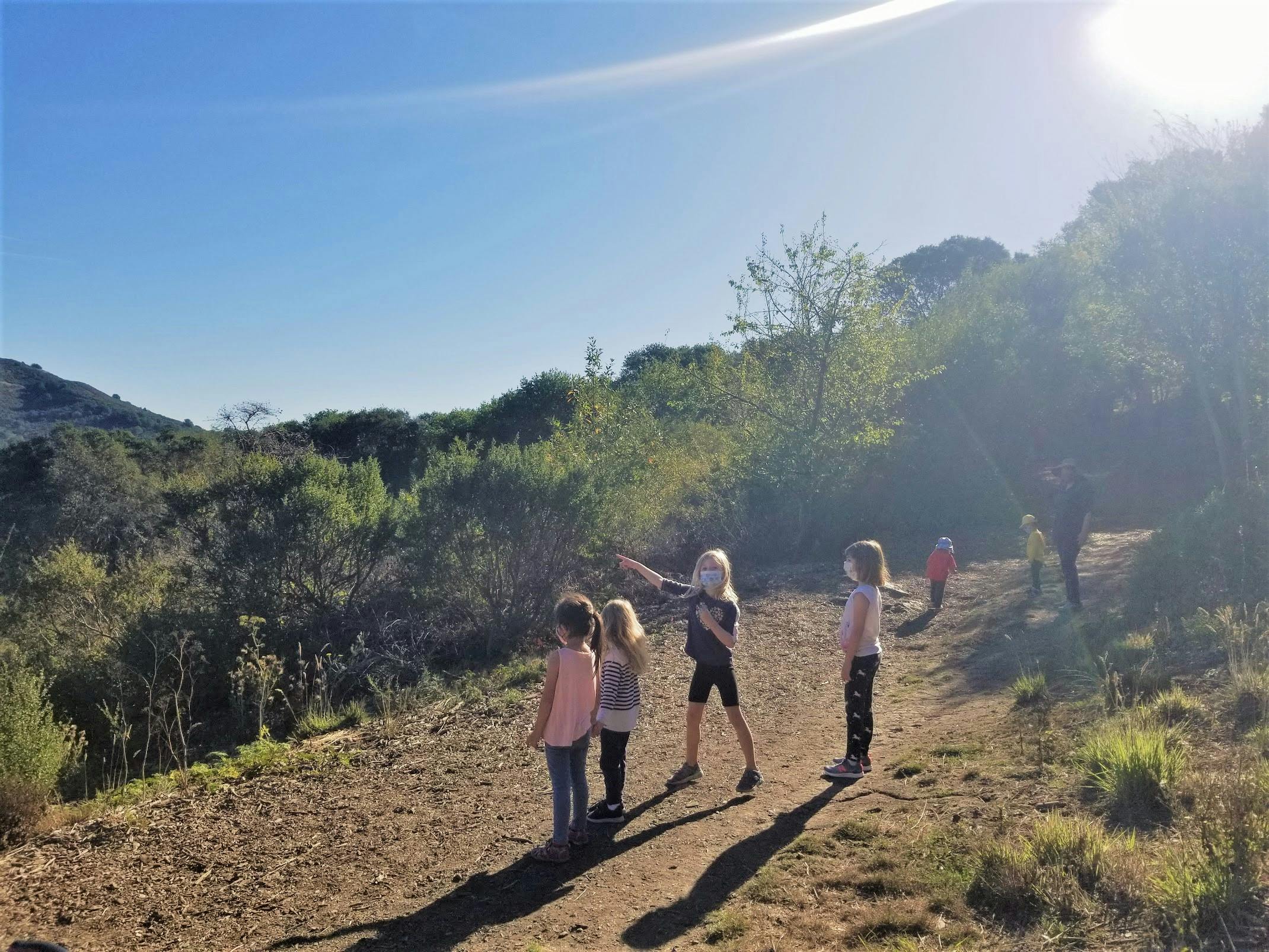 Children standing on a dirt path with one child pointing