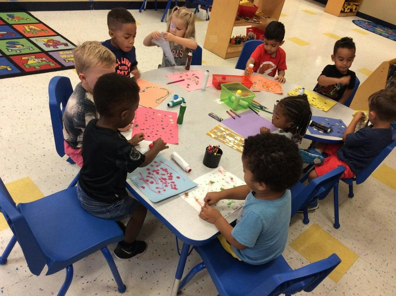 Children sitting around a table doing crafts in-class activities