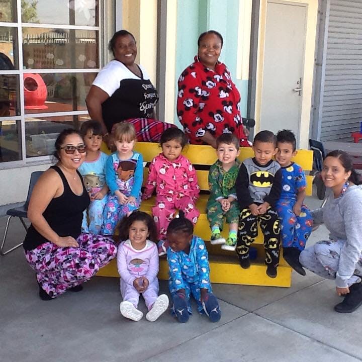 Adults and children in pajamas posing for a photo