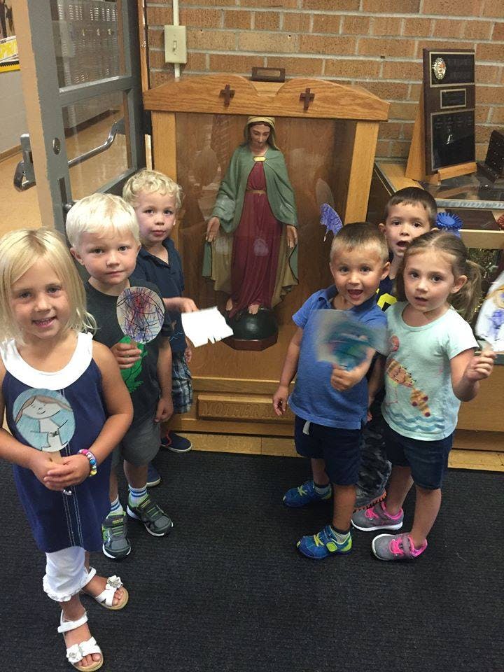 Group of children standing near a statue
