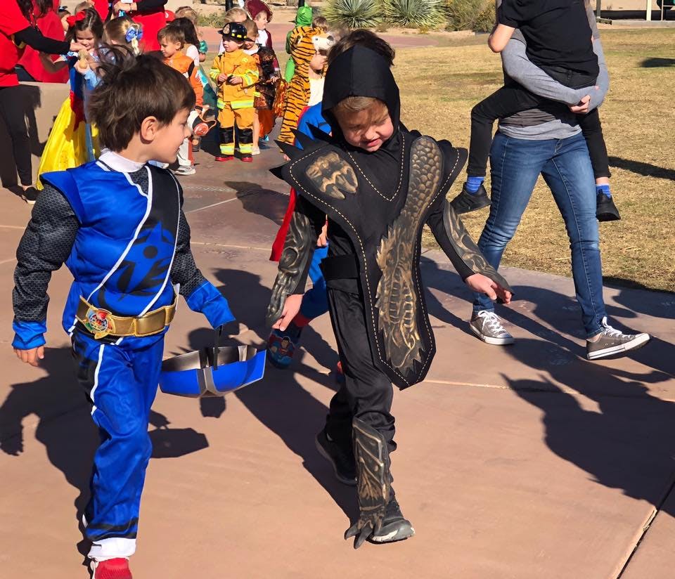 Two children in costumes walking outdoors