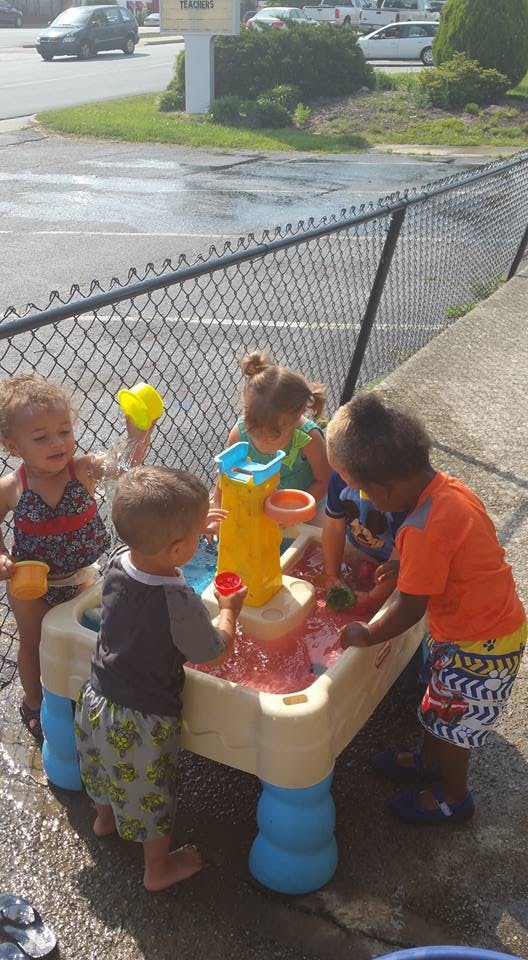 Children playing with a water table outdoors