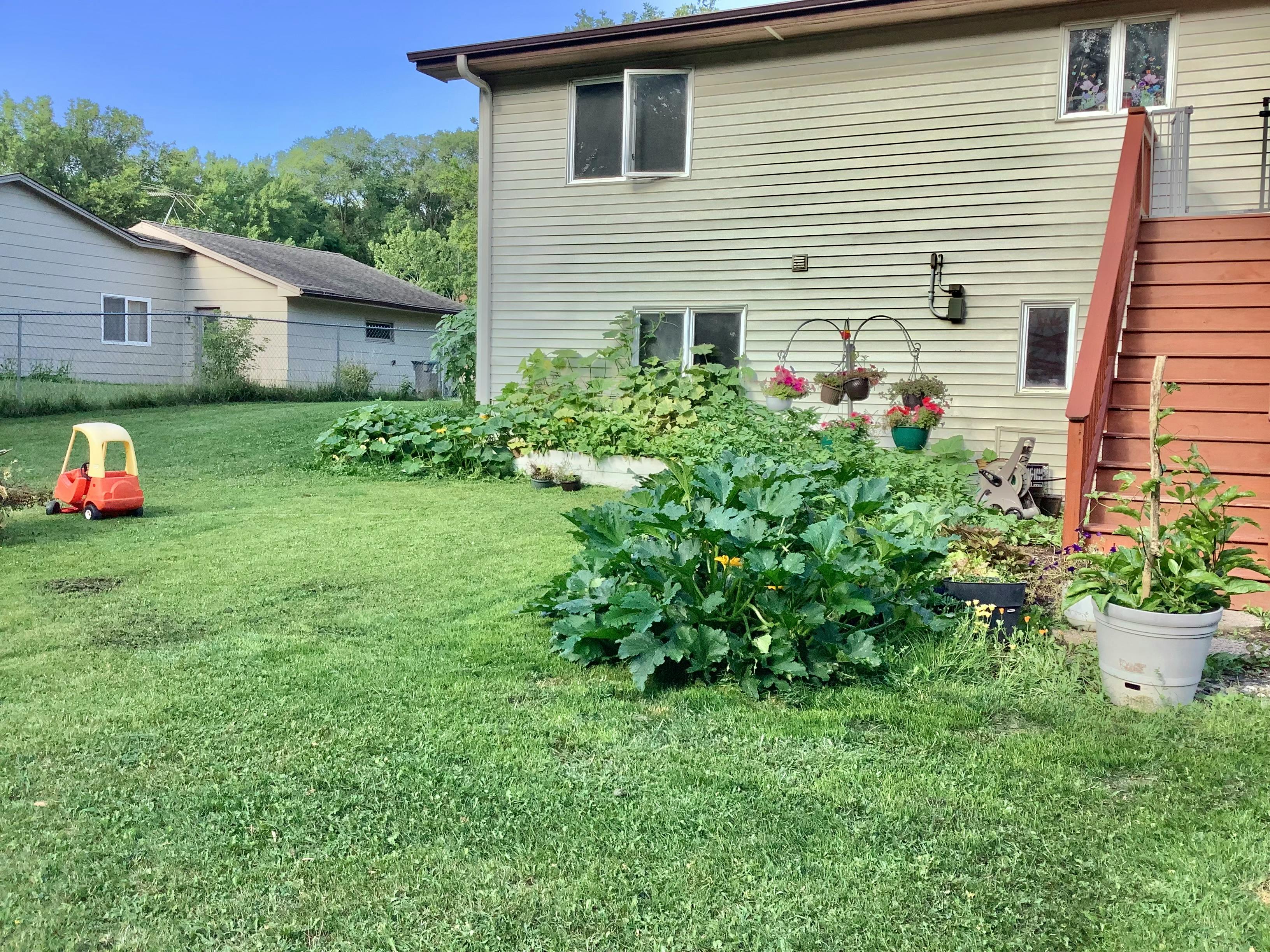 Backyard with a house, garden, and a small toy car