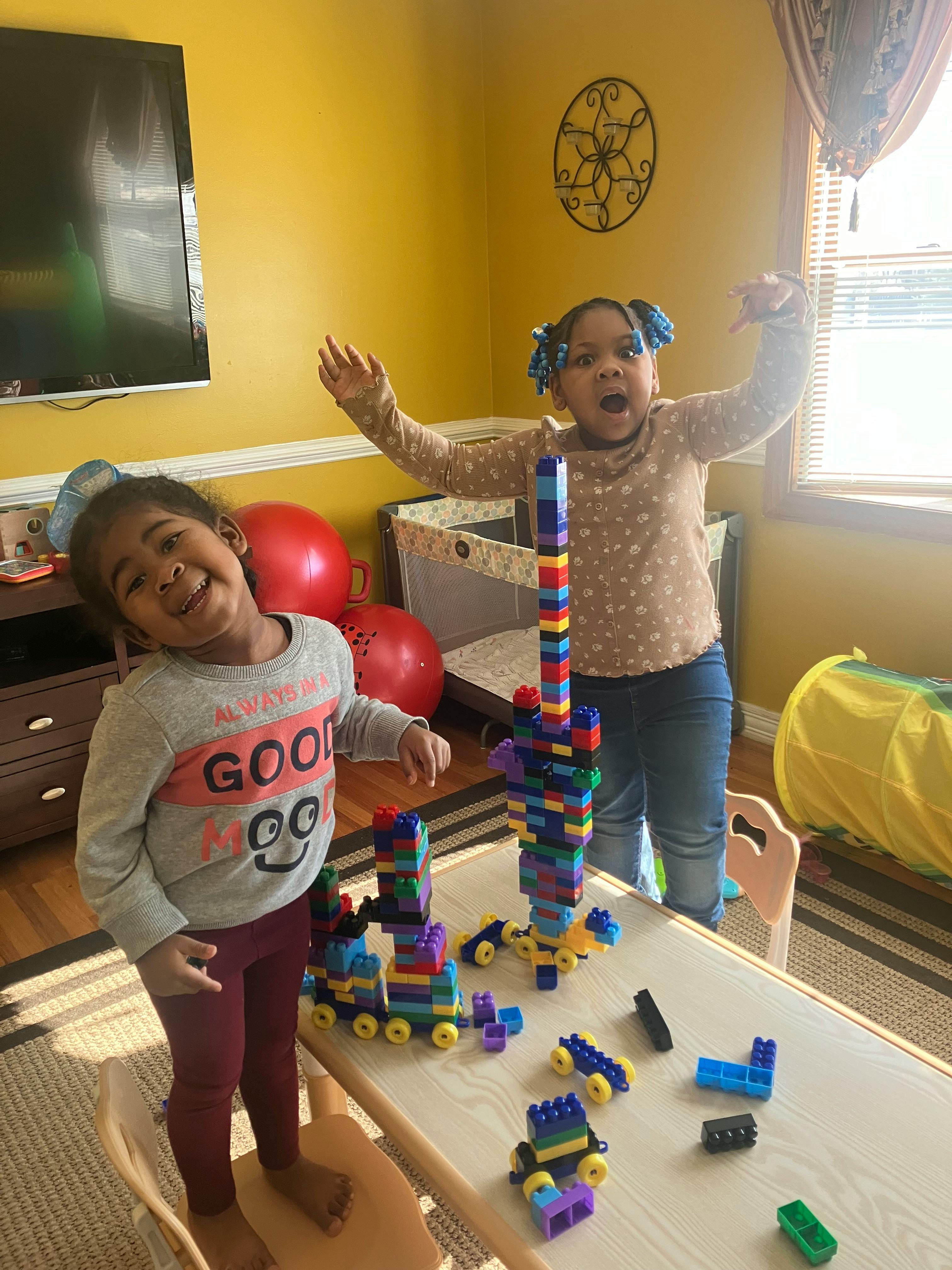 Two children playing with colorful building blocks on a table