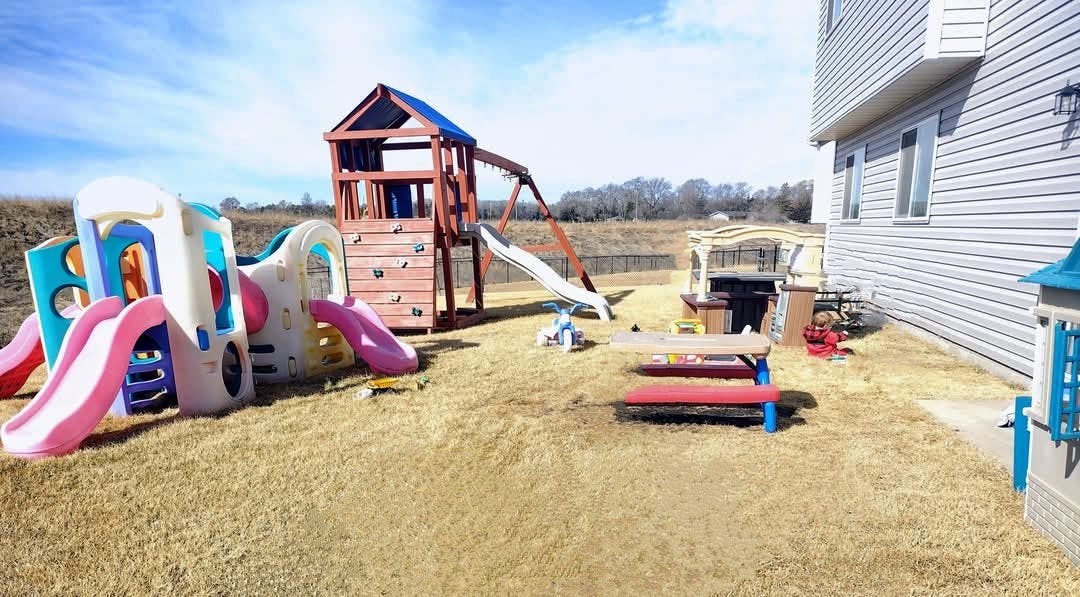 Playground with slides and climbing structure next to a building