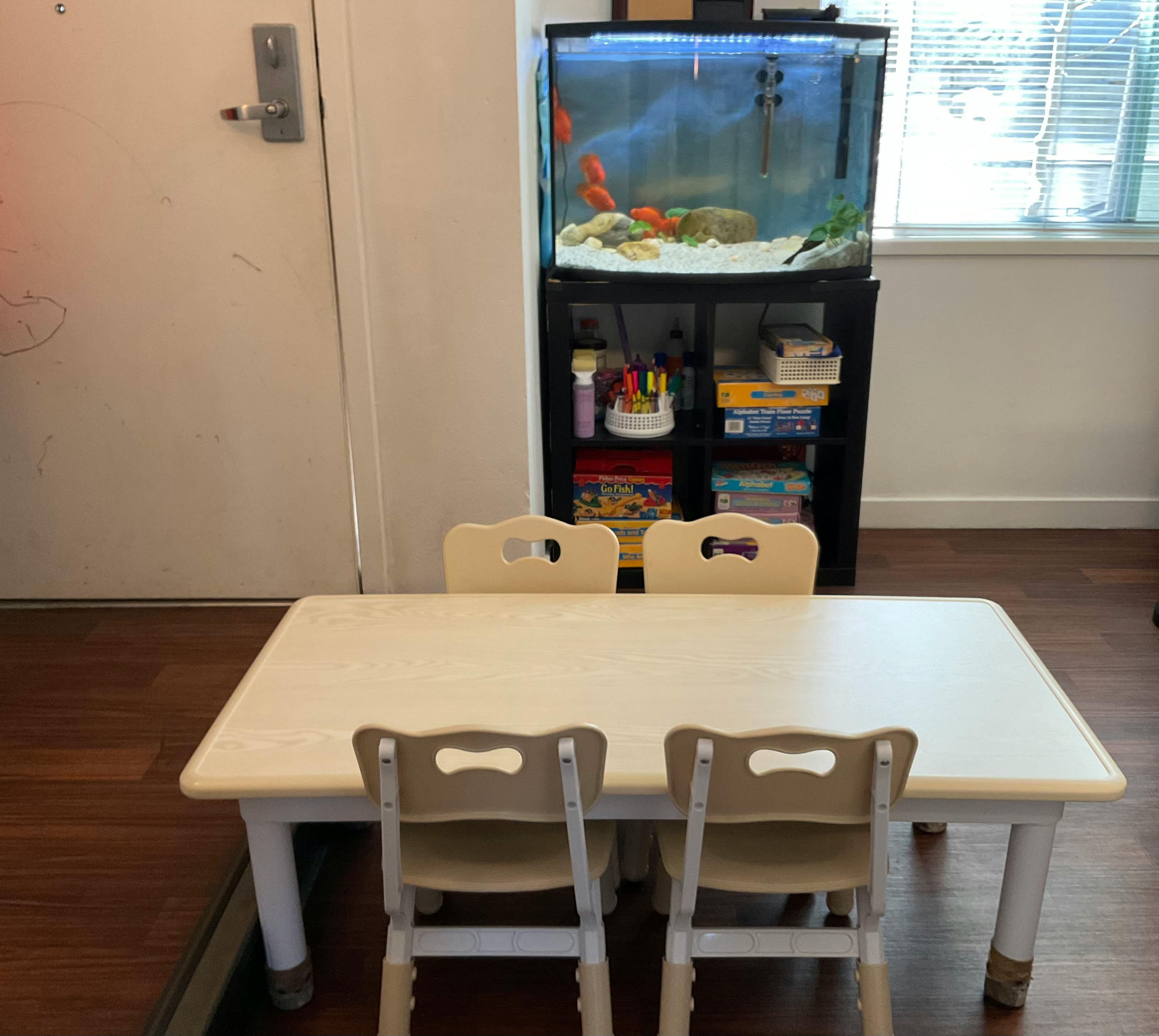 Children's table and chairs in a room with a fish tank