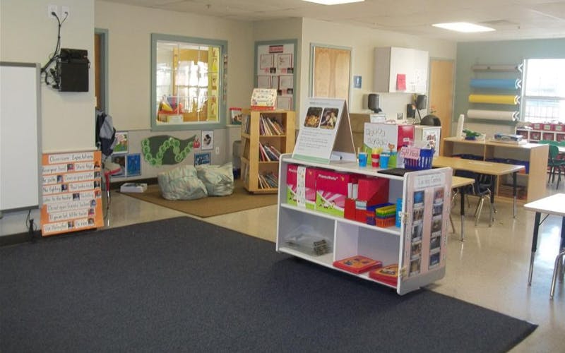 Classroom with bookshelves, tables, and a whiteboard