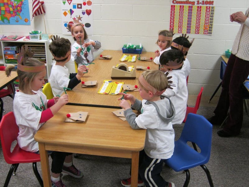 Children sitting at a table doing crafts in-class activities