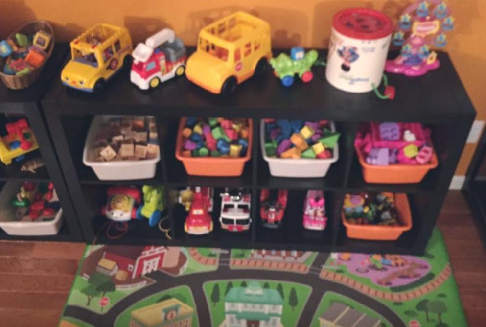 Toy storage shelf with bins of toys and toy vehicles on top