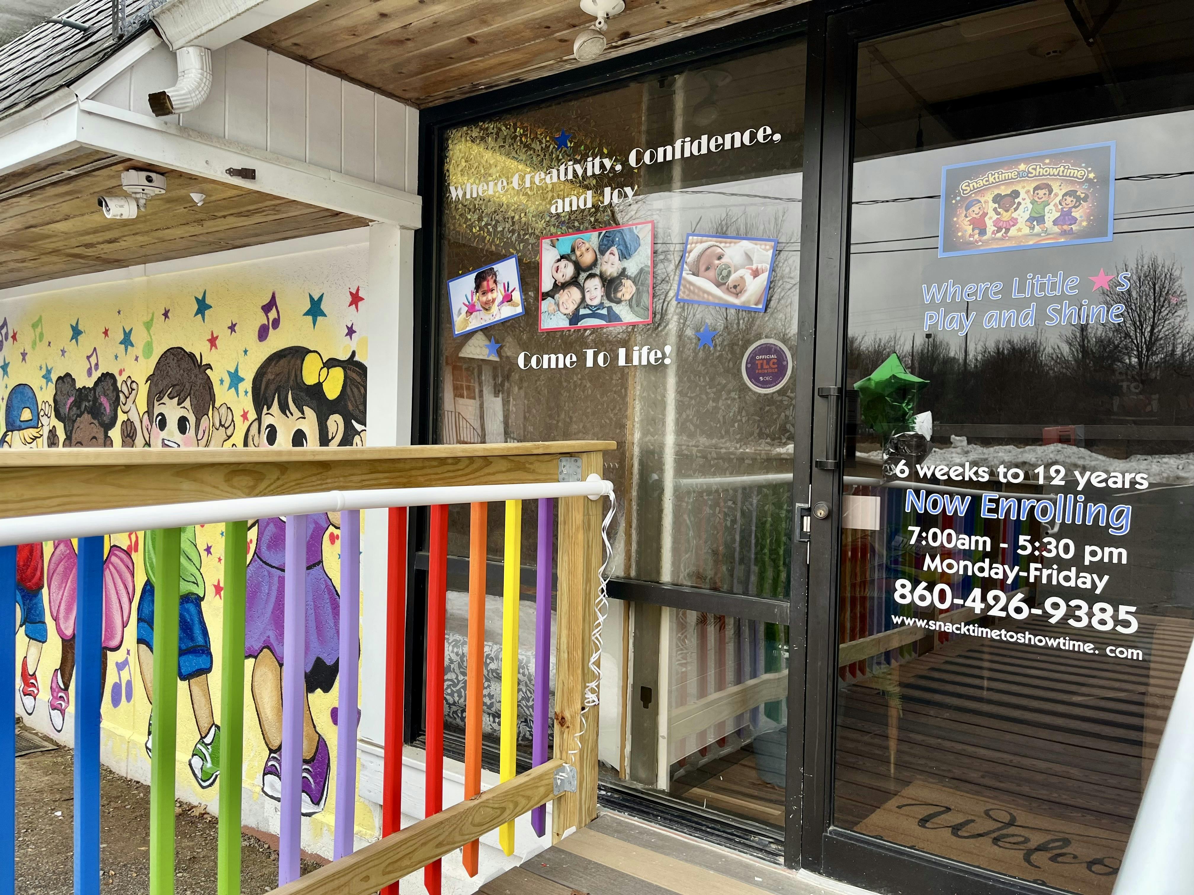 Entrance to a daycare with a colorful mural and text on the door