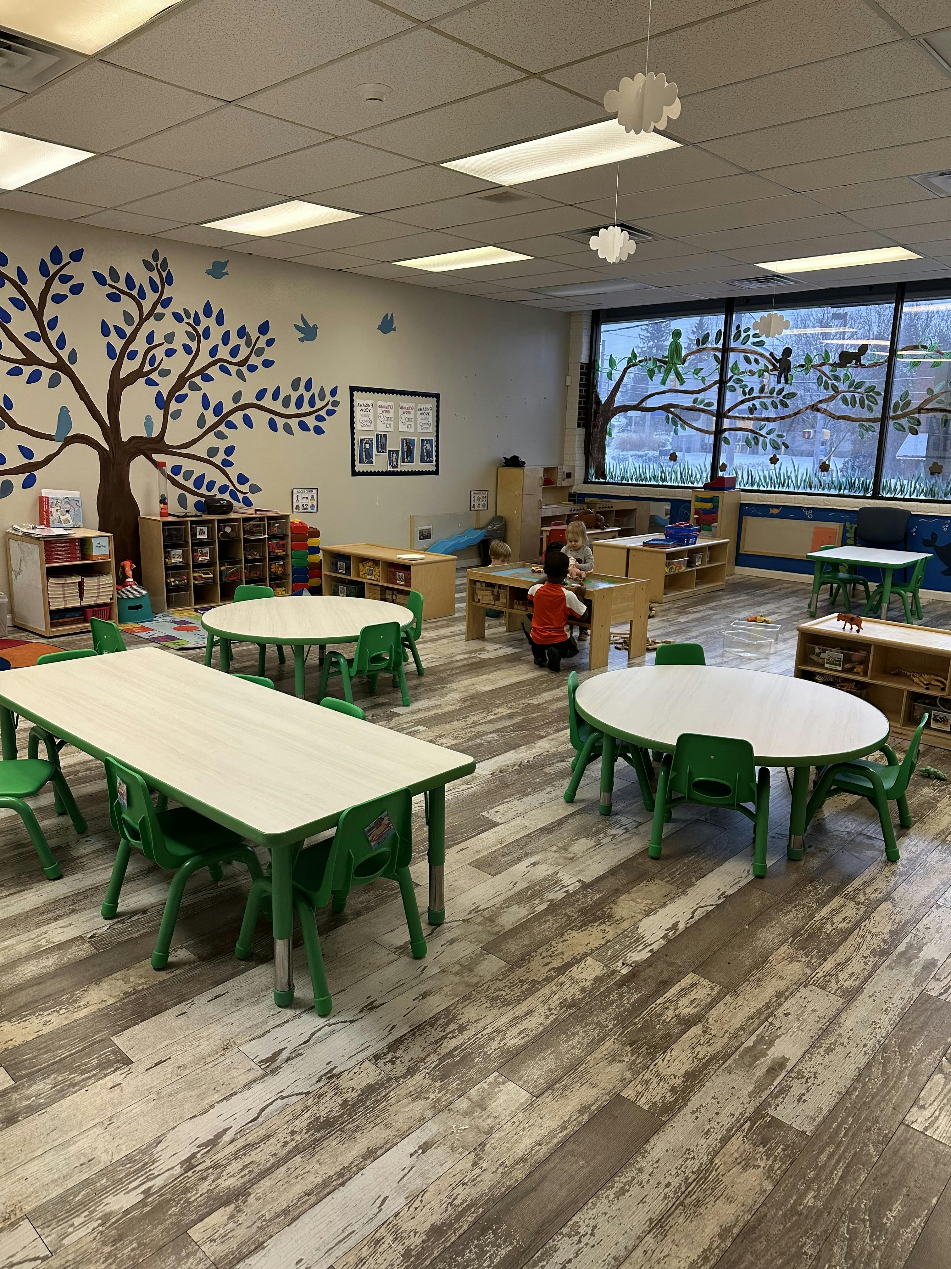 Child in a classroom with tables and chairs