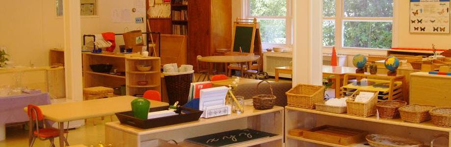 Classroom with wooden shelves, tables, and learning materials
