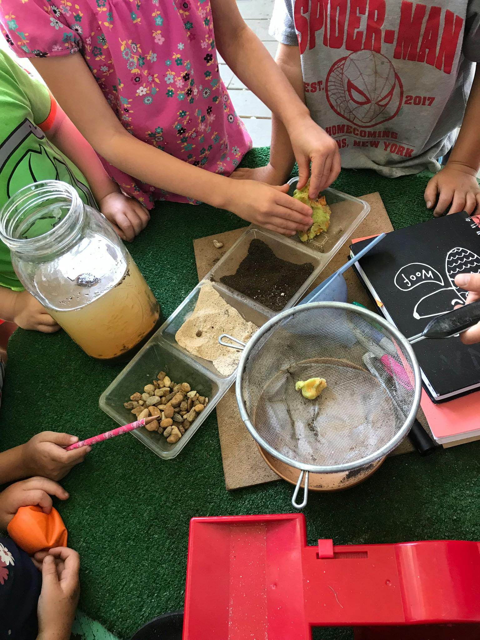 Children playing with various materials in containers