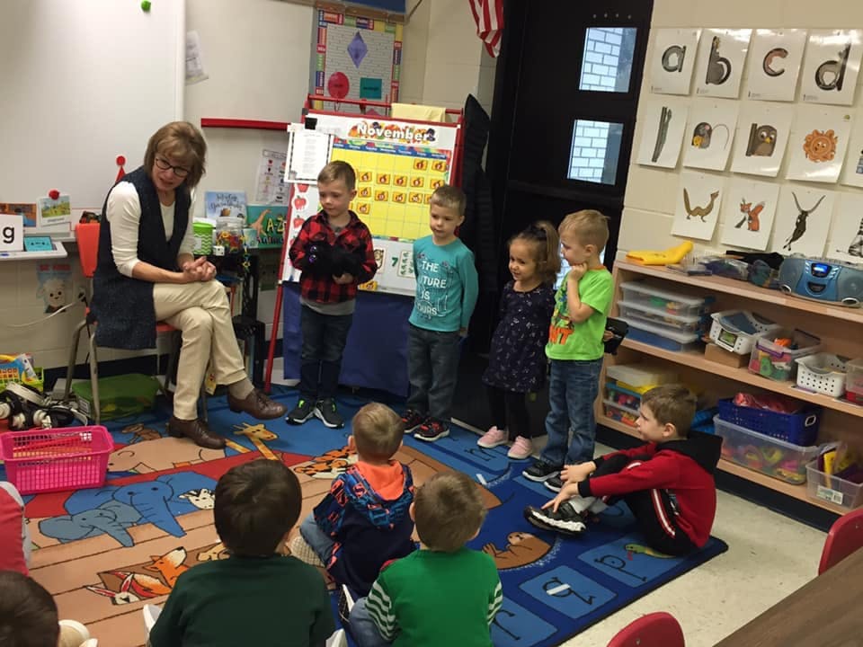 Adult reading to children in a classroom