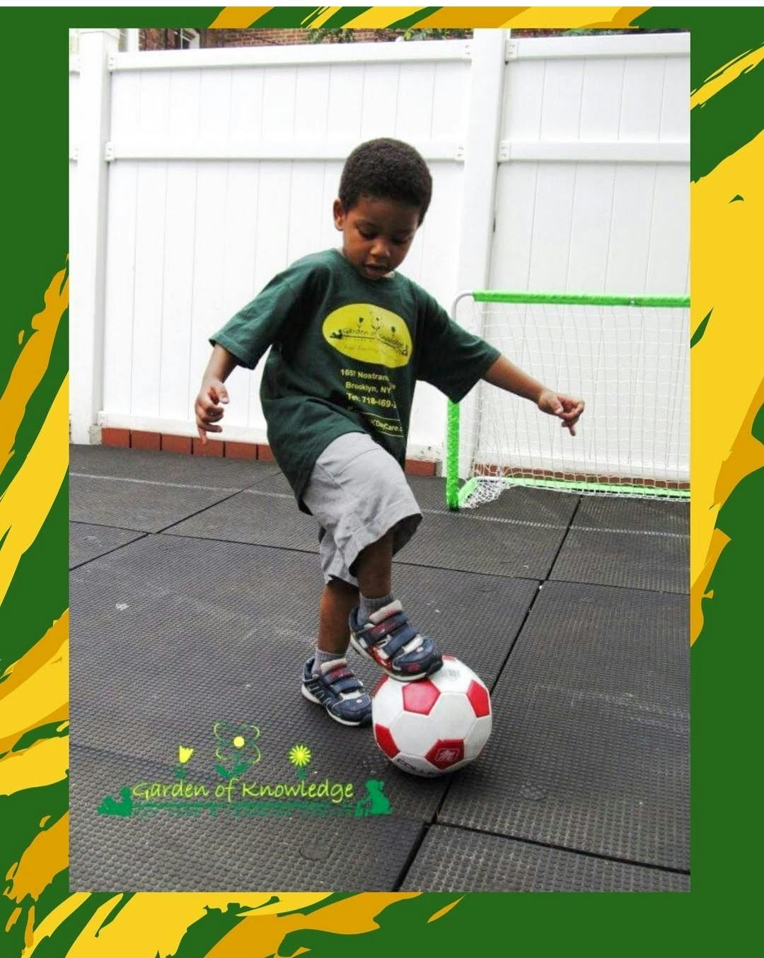 Child standing with a foot on a soccer ball outdoors