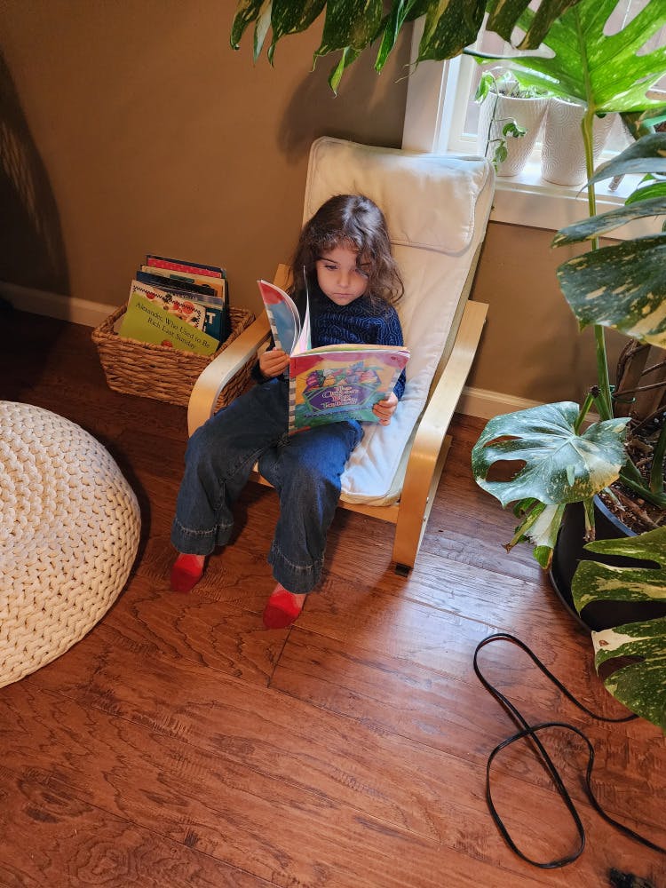 A child sitting in a chair reading a book