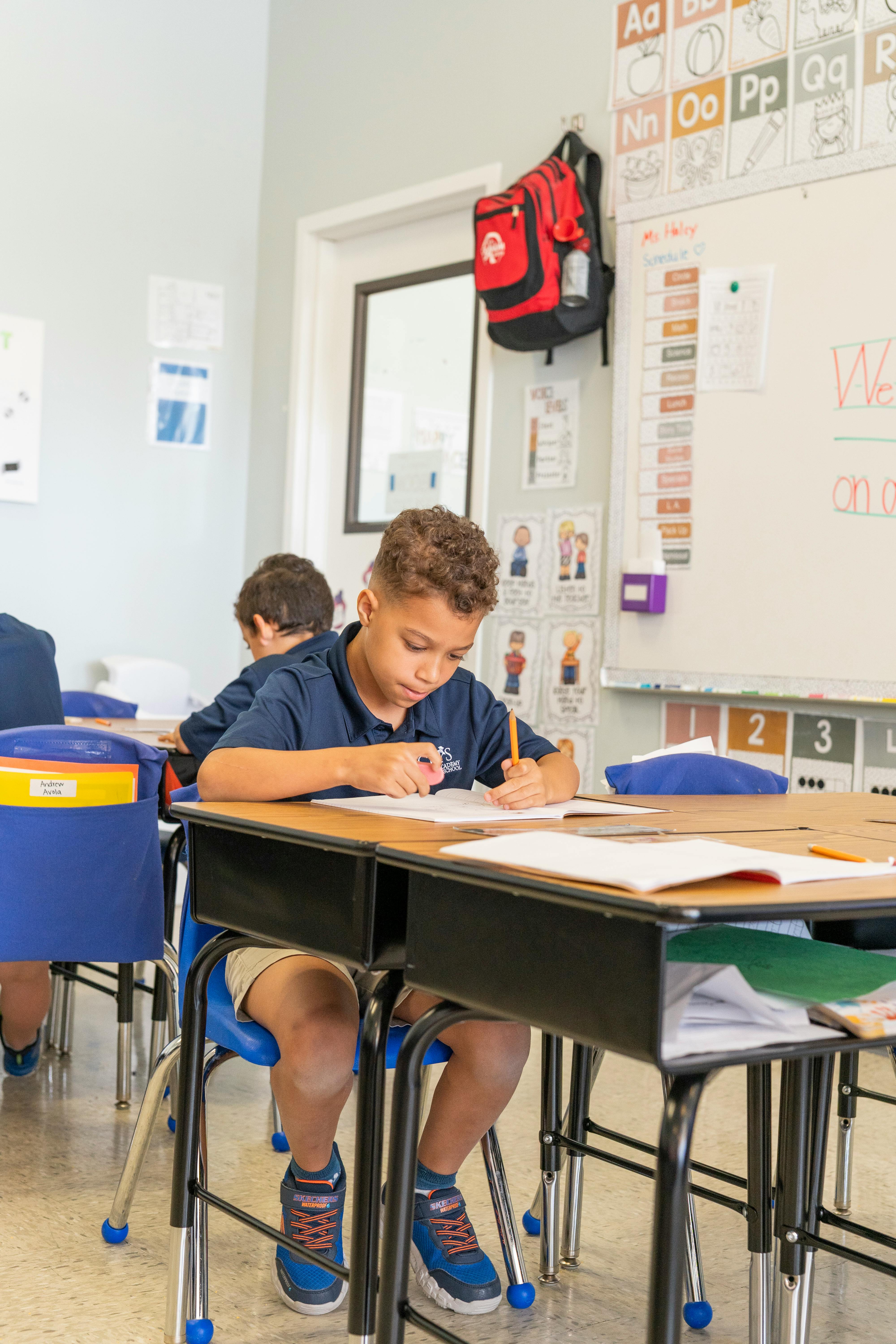 Child writing at a desk in a classroom