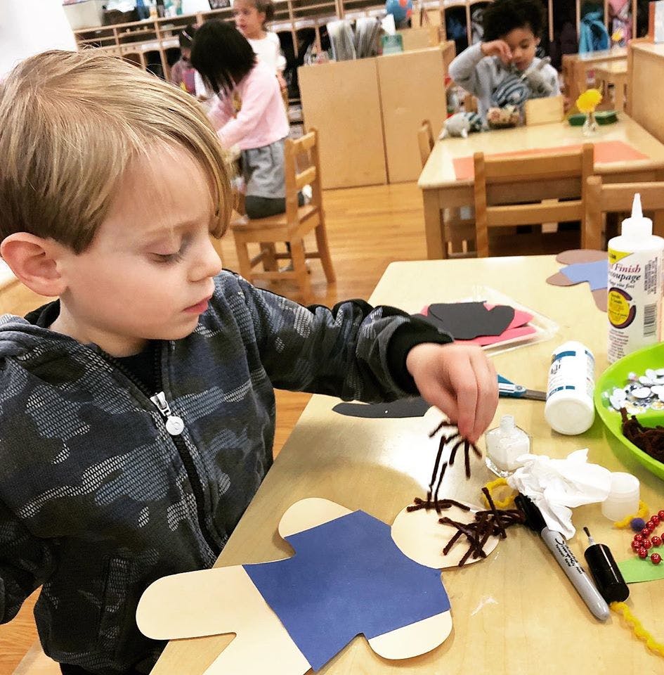 Child making a craft in a classroom