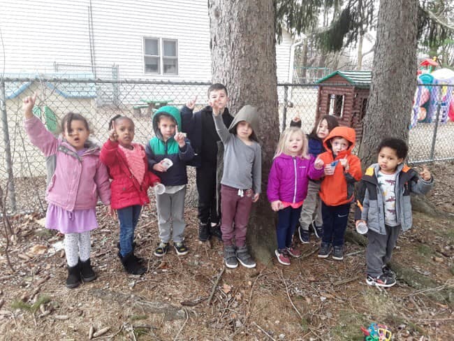 Group of children standing outdoors near trees
