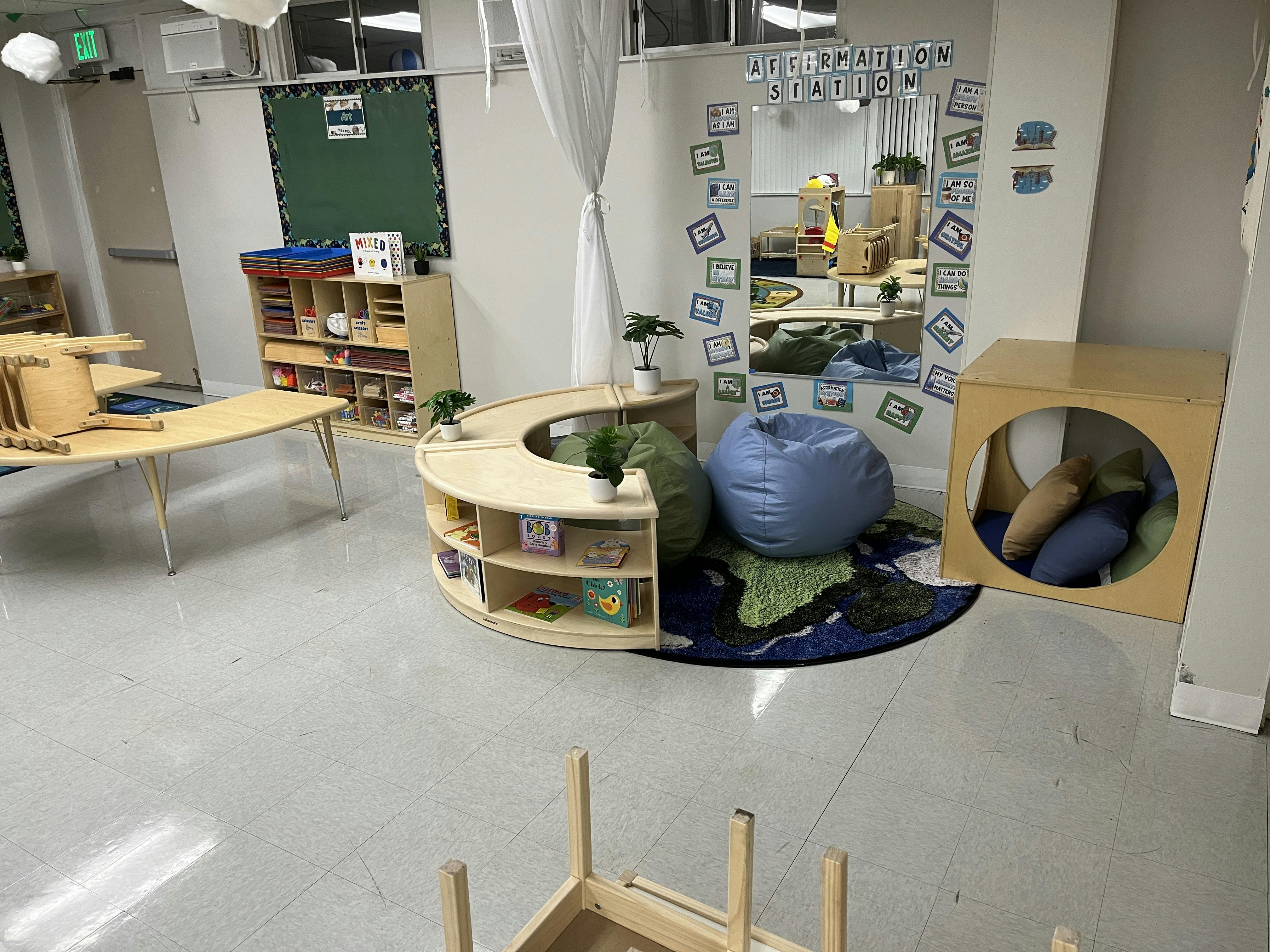 Classroom corner with books, bean bag chairs, and a mirror