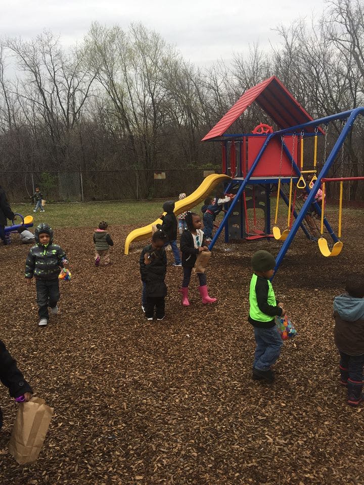 Children playing on a playground with a slide and swings